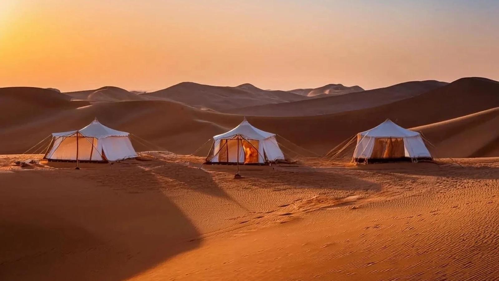 Stimmungsvoll beleuchtetes Wüstencamp zwischen den Dünen der Wahiba Sands